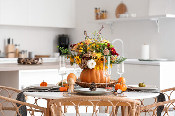 Pumpkin with autumn bouquet on dining table in kitchen