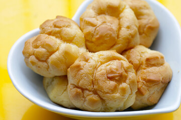 Cream puffs on yellow background