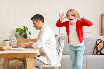 Working young man stressed of his noisy little son at home
