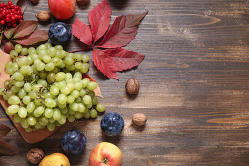 Board with different fresh fruits on wooden background