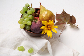 Bowl with different fresh fruits on white background