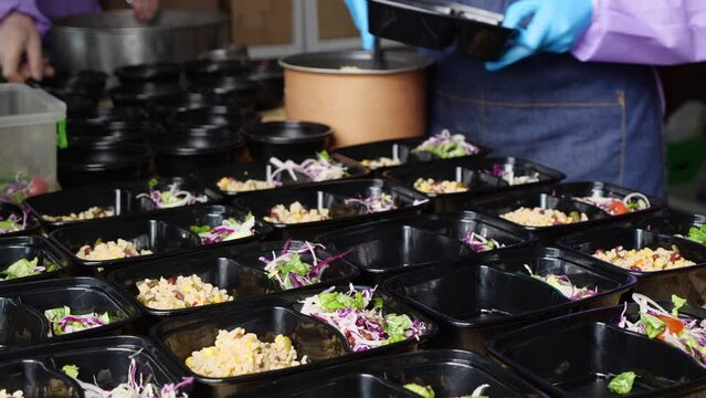 Volunteers prepare food in the kitchen. Lunch boxes with hot meals. Community Meal Center. Senior Meal Program