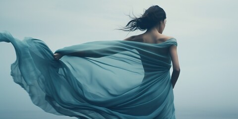 Woman Dancer in Blue Waving Fabric. Ballerina dancing Back bending in Chiffon flying on Wind. Ballet Dance. Fit Body Women Silhouette Wrapped in Cyan Cloth over Gray hiding Face : Generative AI