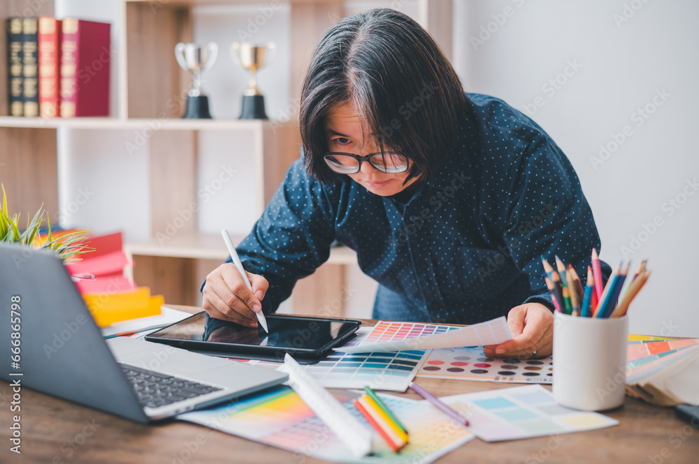 Fototapete Graphic designer architects who work with laptops and color comparison tables for design work..