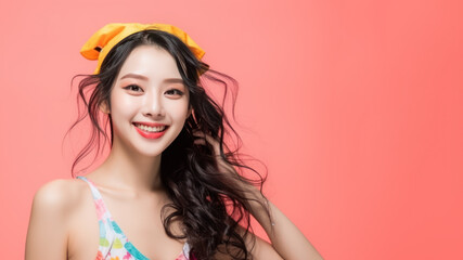 Naklejka premium Smiling chinese woman wearing swimsuit playing water splash