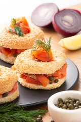 Smoked salmon, cream cheese and caper bagels rest on a plate.