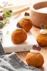 Arancini balls on a light filled work surface. 