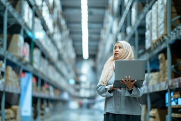 Portrait of Asian muslim female headscarf hijab holding computer laptop checklist product shelves...
