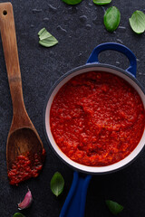 Tomato sauce rests in a pot, ready for pizza making.