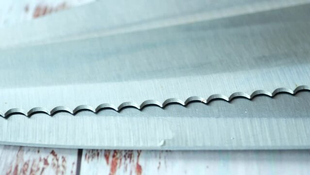 Close-up of a black kitchen knife on a wooden table..