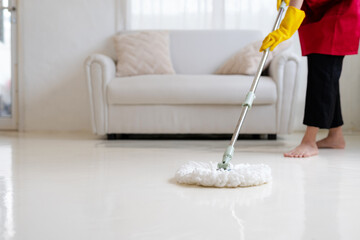 Woman working mopping the house. Housewife in gloves wearing an apron is cleaning the house.