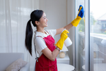 Young asian woman cleaning window.