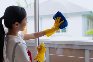 Young asian woman cleaning window.