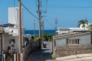 Fototapeta na wymiar くっきりした水平線の見える海が見える集落の道