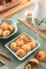 A crispy and crunchy snack shaped like a pastel cake with a small size and containing savory shredded beef