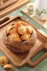 A crispy and crunchy snack shaped like a pastel cake with a small size and containing savory shredded beef