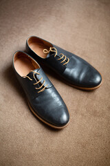 Grooms black coloured leather shoes on carpeted floor
