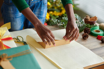 Closeup image of Black woman wrapping Christmas presents