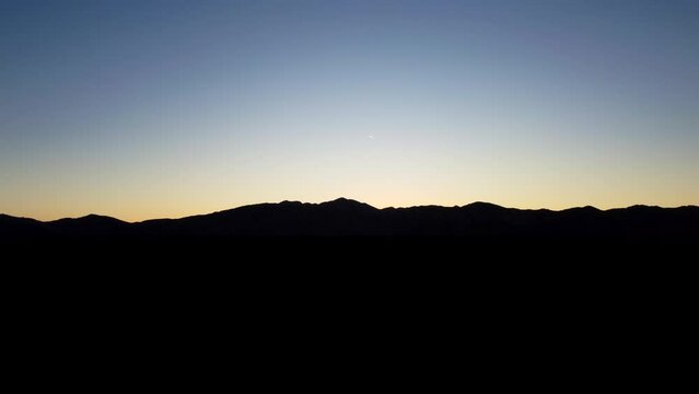 Mountain silhouetted on horizon at blue hour. Sunset nature landscape