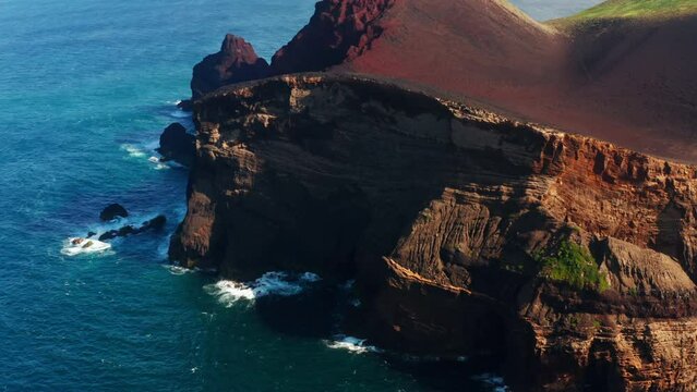 Flying over the Capelinhos red rocky coastline n the Faial island, Azores - Portugal.