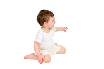 A happy baby is sitting on a studio, isolated on white background. Full-length portrait of a smiling child, isolated on white background. Kid aged about two years (one year nine months)