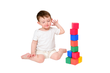Happy baby play educational toys on studio, isolated on white background. Portrait of a smiling child playing while sitting on the floor. Kid about two years old (one year nine months)