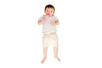 Happy baby drinks milk from bottle on studio, isolated on white background. Resting child eats formula, isolated on white background. Kid about two years old (one year nine months)