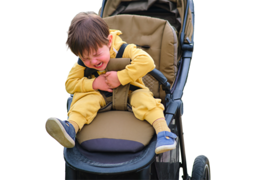 The crying baby in the stroller creates a sad expression on his face in the park, isolated on white background. Kid aged two years (two-year-old boy)
