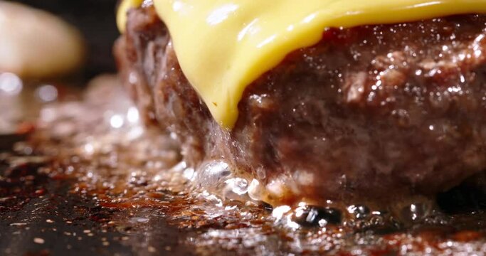 Macro shot of frying cutlets with melted cheese on top. Cinematic advertisement burger cooking. Homemade burger with cheese on grill pan. Flavorful, pan-fried pork cutlets. Fat high calorie food