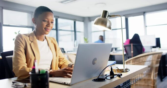 Portrait of smiling african american businesswoman using laptop in office, slow motion, copy space