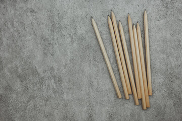 Many sharp pencils on a gray background. Top view. Space for text