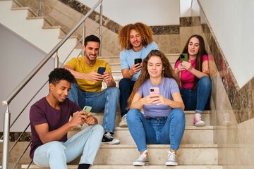 Obraz premium Group university students holding mobile phones watching videos, communication online, chatting at a break.