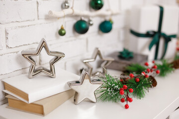 Christmas branch of pine tree and stars on shelf