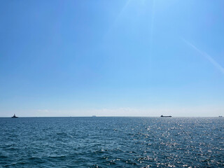 青空と太陽の光に照らされてキラキラと光り輝く海景色