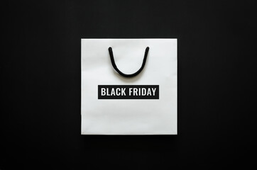 White shopping bag with Black Friday word on black background for Black Friday shopping concept.