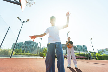 Children and sports. Teenage girl playing basketball on the playground.