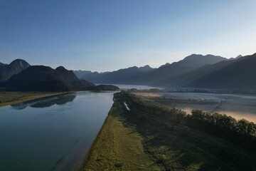 an aerial of Pitt River Dyke in Pitt Meadows on hills BC on a sunny day