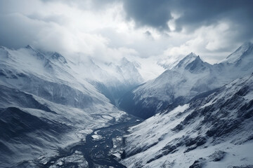High angle shot of a beautiful mountain range covered with snow under the cloudy sky, aesthetic look