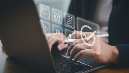 Businessman using computer laptop checking quality assurance and approval for service guarantee, certification, standardization, quality control and service approval concept.
