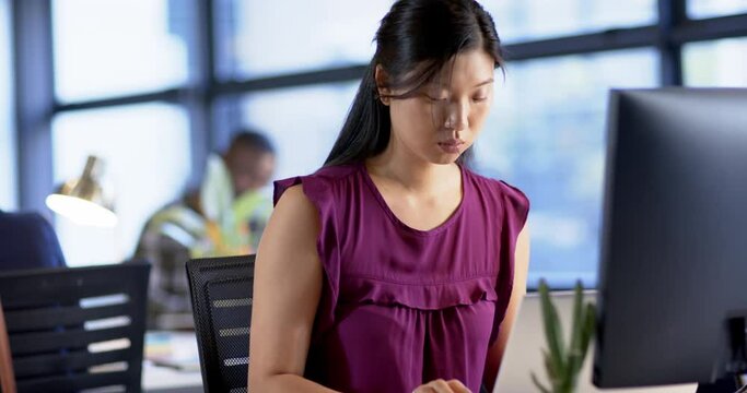 Portrait of asian businesswoman using computer in office, slow motion, copy space