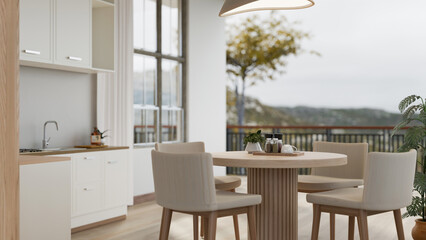 A modern Scandinavian kitchen with a dining table and a beautiful view through a balcony.