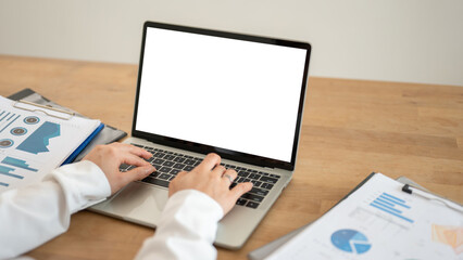 Close-up image of a businesswoman using her laptop at her desk. A white-screen laptop mockup.