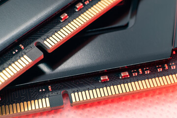 DDR4 DRAM memory modules in red light. Computer RAM chip with golden contacts hardware close-up. Desktop PC memory parts