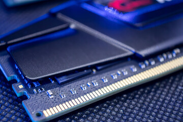 Memory module DDR4 DRAM with electrical contacts in blue light. Computer RAM chipset close-up. Desktop PC hardware components