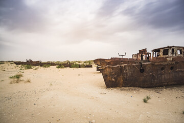 Rusty ships and boats in the desert at the bottom of the dried up Aral Sea in Uzbekistan, an...