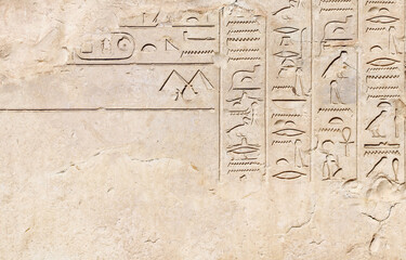 Horizontal background with ancient Egyptian hieroglyphs on stone wall, Egypt, Africa. Backdrop with sandstone carving with hieroglyph. Mock up template. Copy space for text