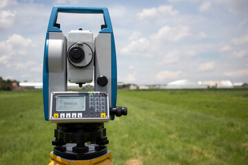 total station in the field; survey equipment in a green land being measured