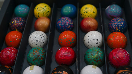Candy chocolate balls sweats sprinkled with pigments in box.