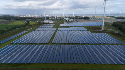 Solar panel park with windmills in background, Aerial
