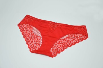 Lingerie. Red lace sexy panties on a white background. Fashionable colored women's underwear.